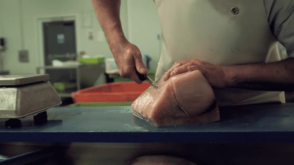 A fish fillet being cut