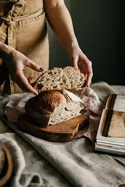 Fresho Software for fresh food wholesale suppliers and their customers - Bread Category - Baker handling a cut loaf of bread