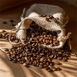 Fresho Software for fresh food wholesale suppliers and their customers - Coffee Category - Roasted coffee beans spilling out of hessian back