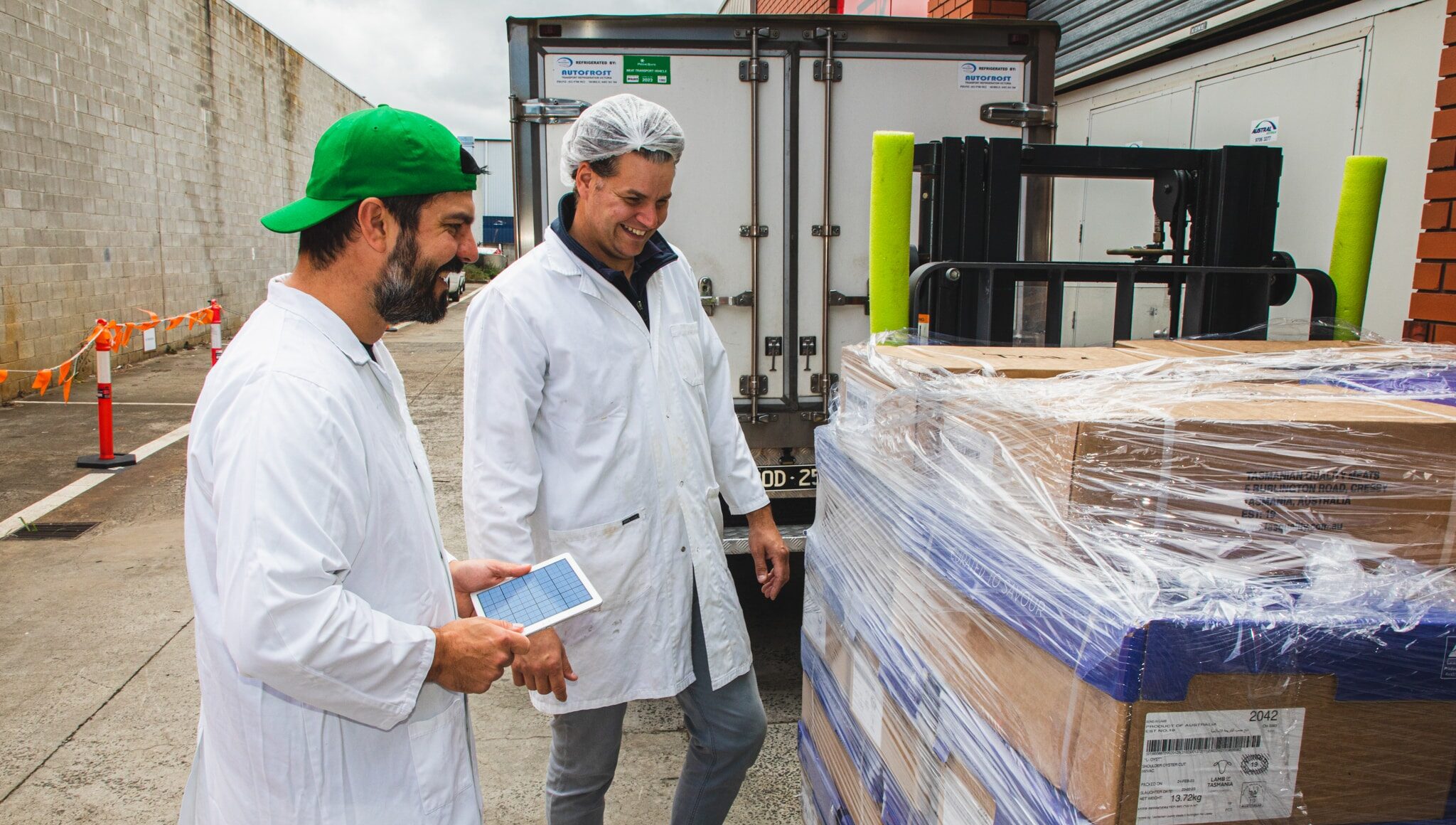 Two men in meat wholesale smiling